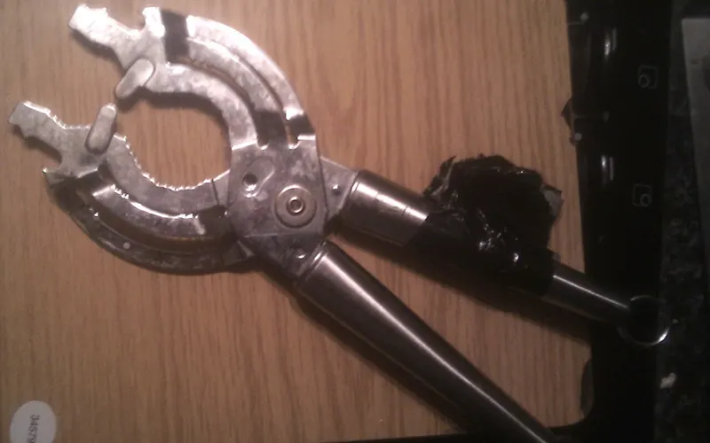 Photo of a hand-held metal jar opener.