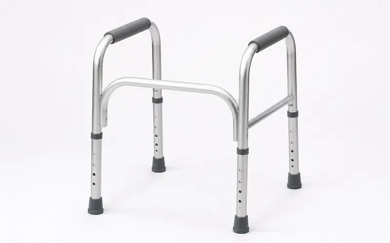 Illustration of a free-standing aluminium toilet safety frame with padded armrests. Shows the type of product, not the exact brand or model.