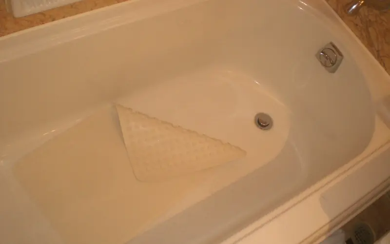 Photo of a non-slip rubber mat lying in the bottom of a bathtub.